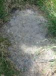 Inscribed slab, partially buried by turf